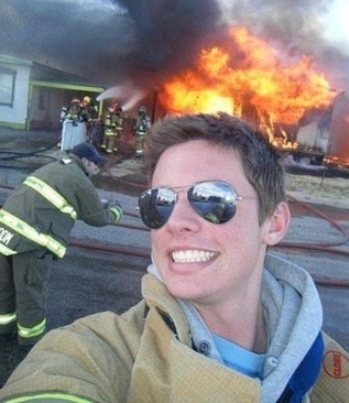 عکس سلفی در کنار آتش سوزی بزرگ در آمریکا در حالی که افراد آتش نشانی در تلاش برای خاموش کردن آتش هستند.
