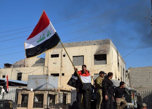 تکان دادن پرچم عراق در مجتمع دولتی
