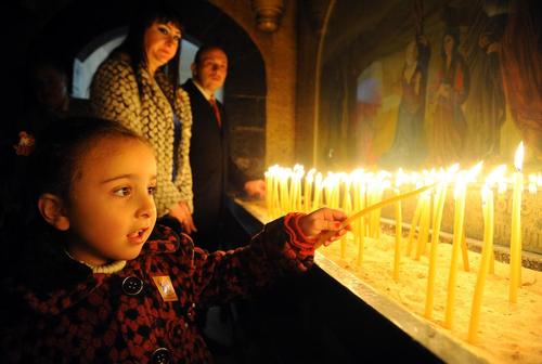روشن کردن شمع برای صلح در کلیسایی در دمشق در مراسم جشن میلاد مسیح